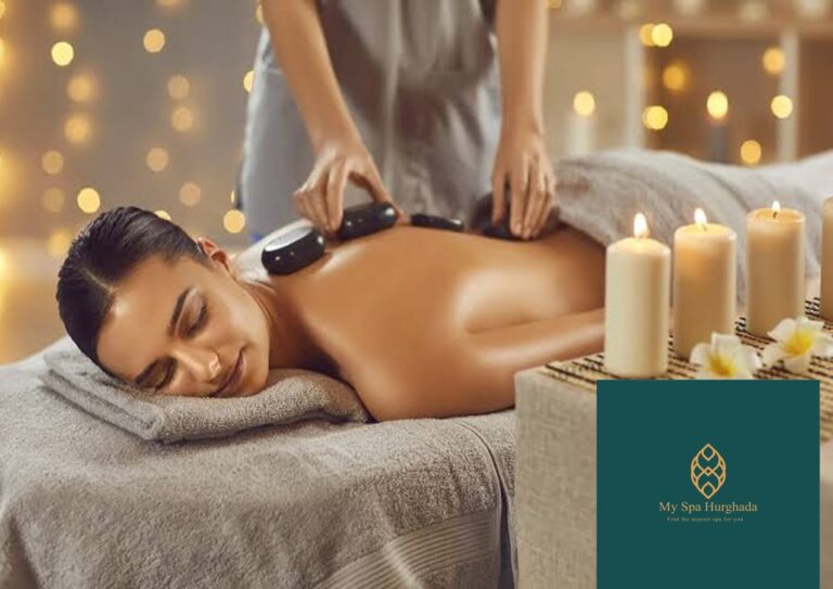 A woman lying peacefully on a massage table receiving hot stone therapy in a serene spa room.
