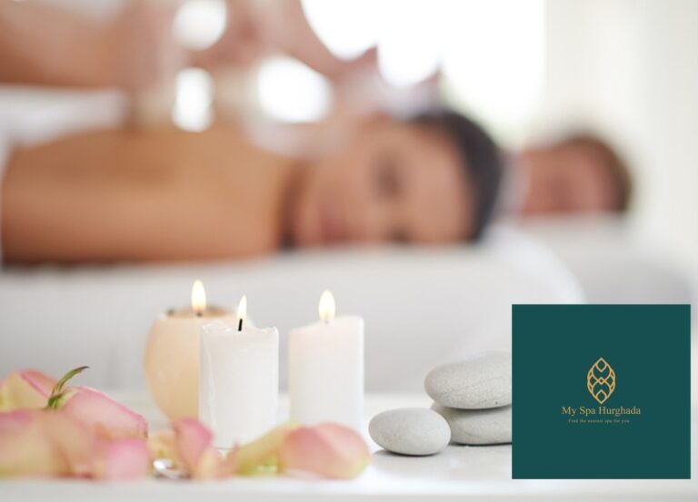 A close-up view of three burning candles, smooth massage stones, and pink rose petals on a white table, with a person receiving a therapeutic back massage in the background, promoting The Cleopatra Program: Egypt’s Most Luxurious Spa Ritual.
